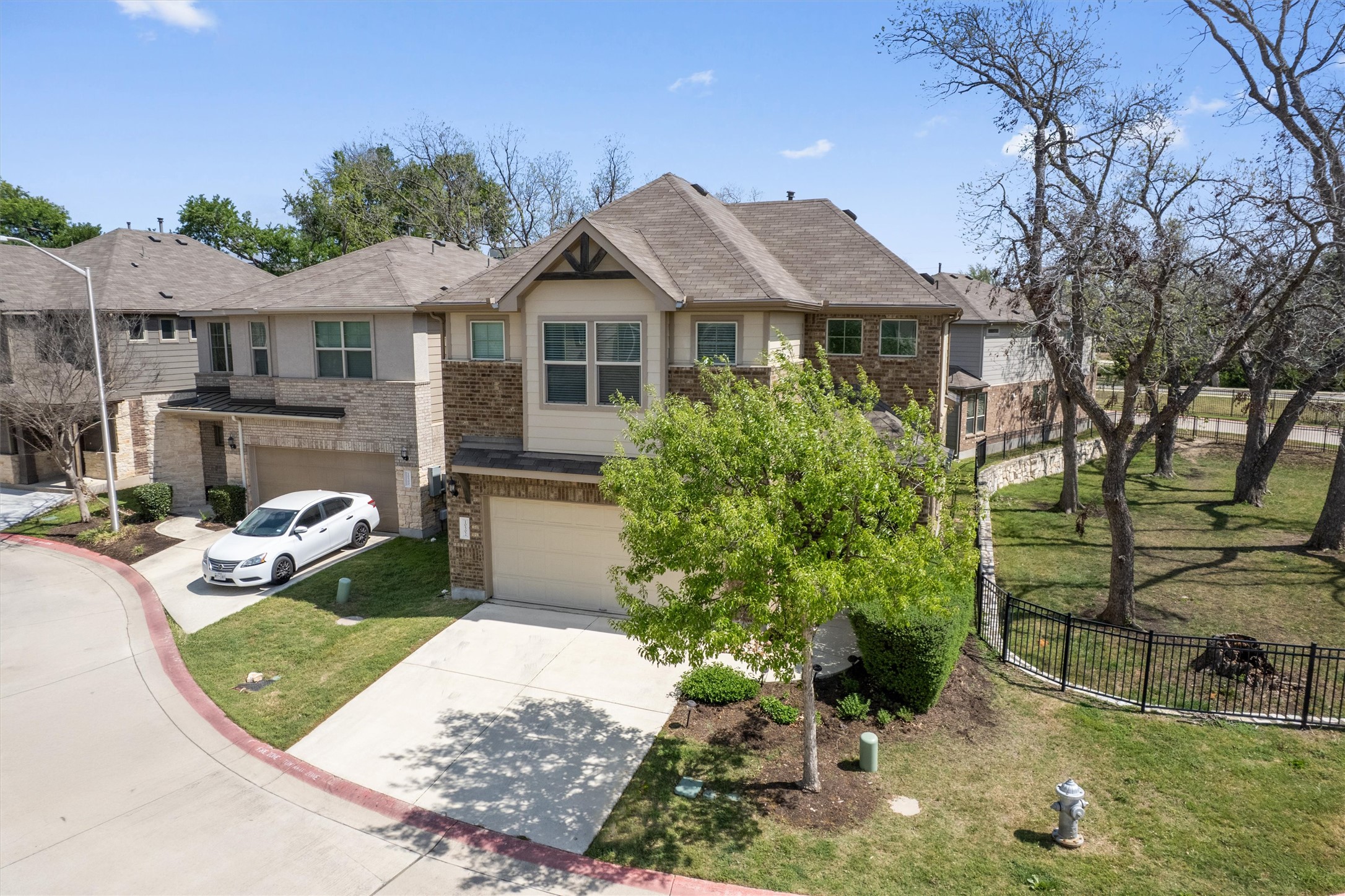 10502 Turnbull Loop, Unit 41 Austin, TX 78717 - Photo 29 of 35 View of front of property with an attached garage, concrete driveway, and brick siding