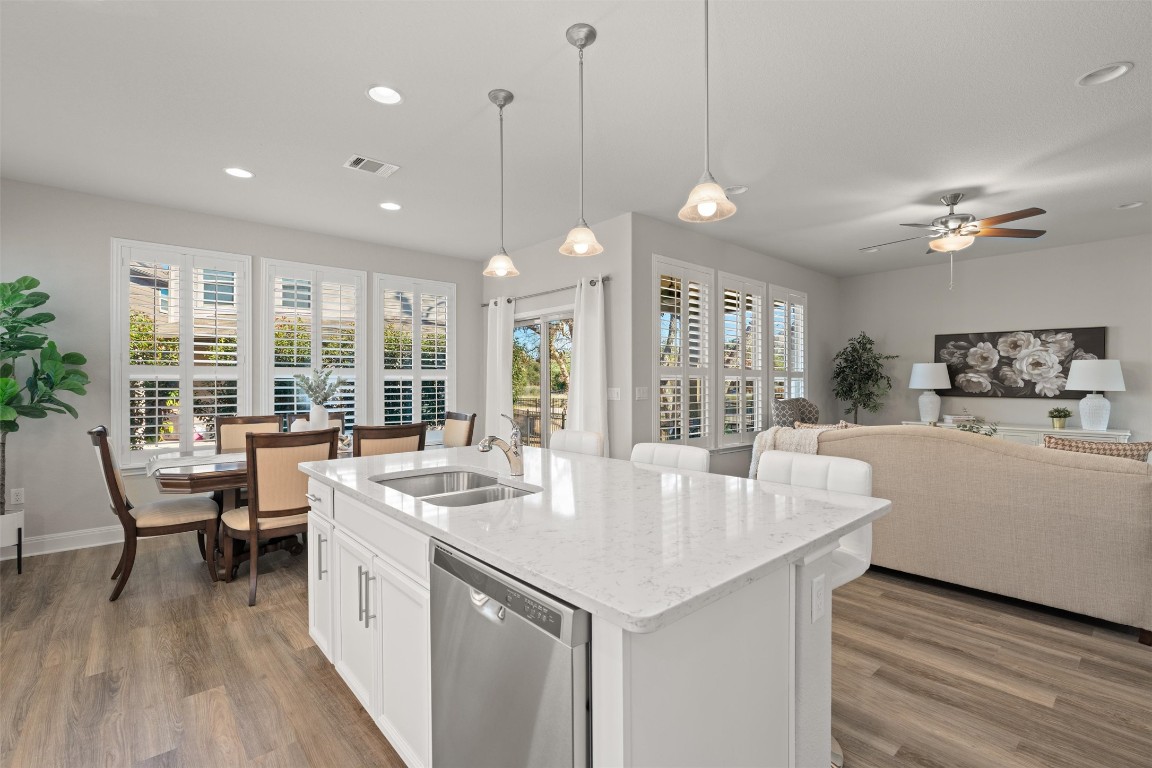 10502 Turnbull Loop, Unit 41 Austin, TX 78717 - Photo 29 of 29 Kitchen featuring light stone countertops, dishwasher, white cabinetry, open floor plan, and pendant lighting
