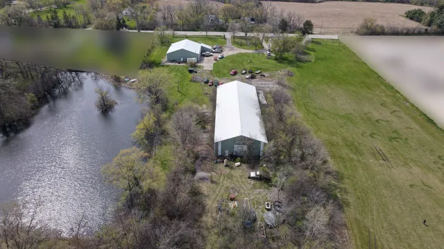 a aerial view of a house with a yard and lake view