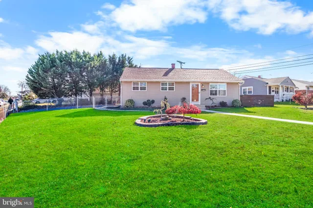 a front view of a house with a yard and trees