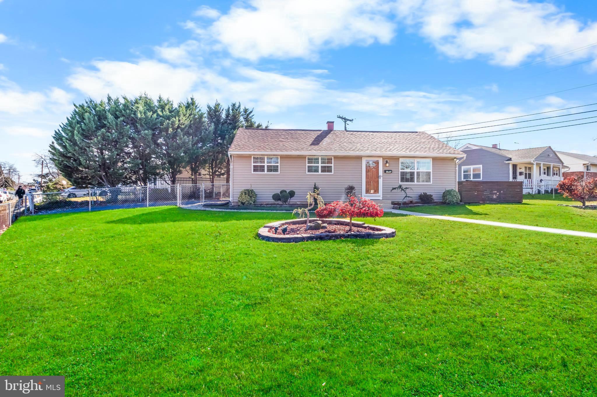a front view of a house with a yard and trees