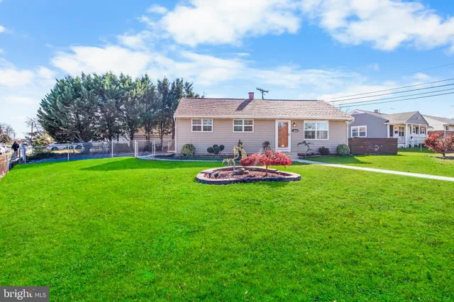 a front view of a house with a yard and trees