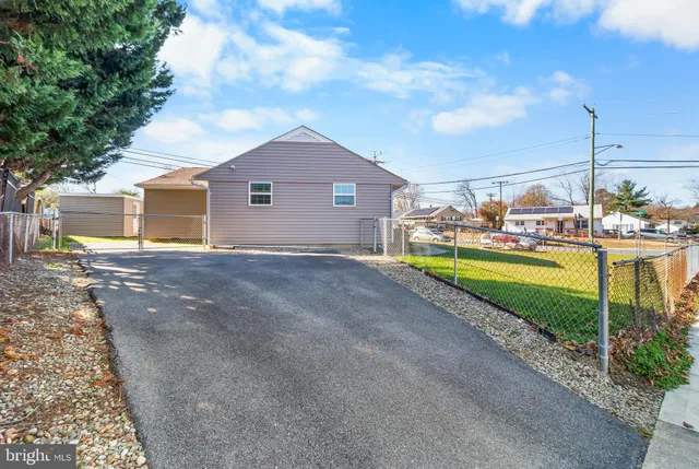 a view of a house with a big yard and large trees