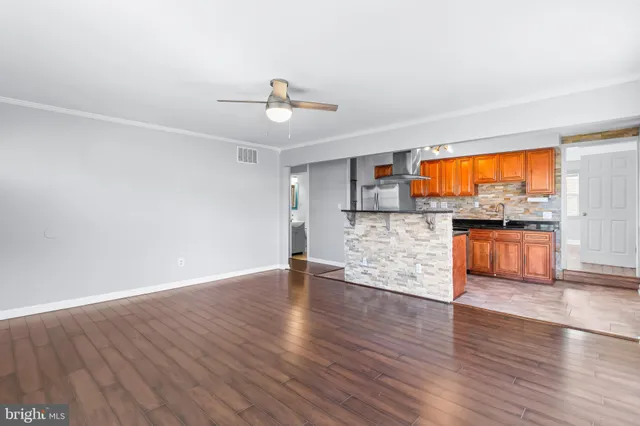 a view of a kitchen with wooden floor and a kitchen space