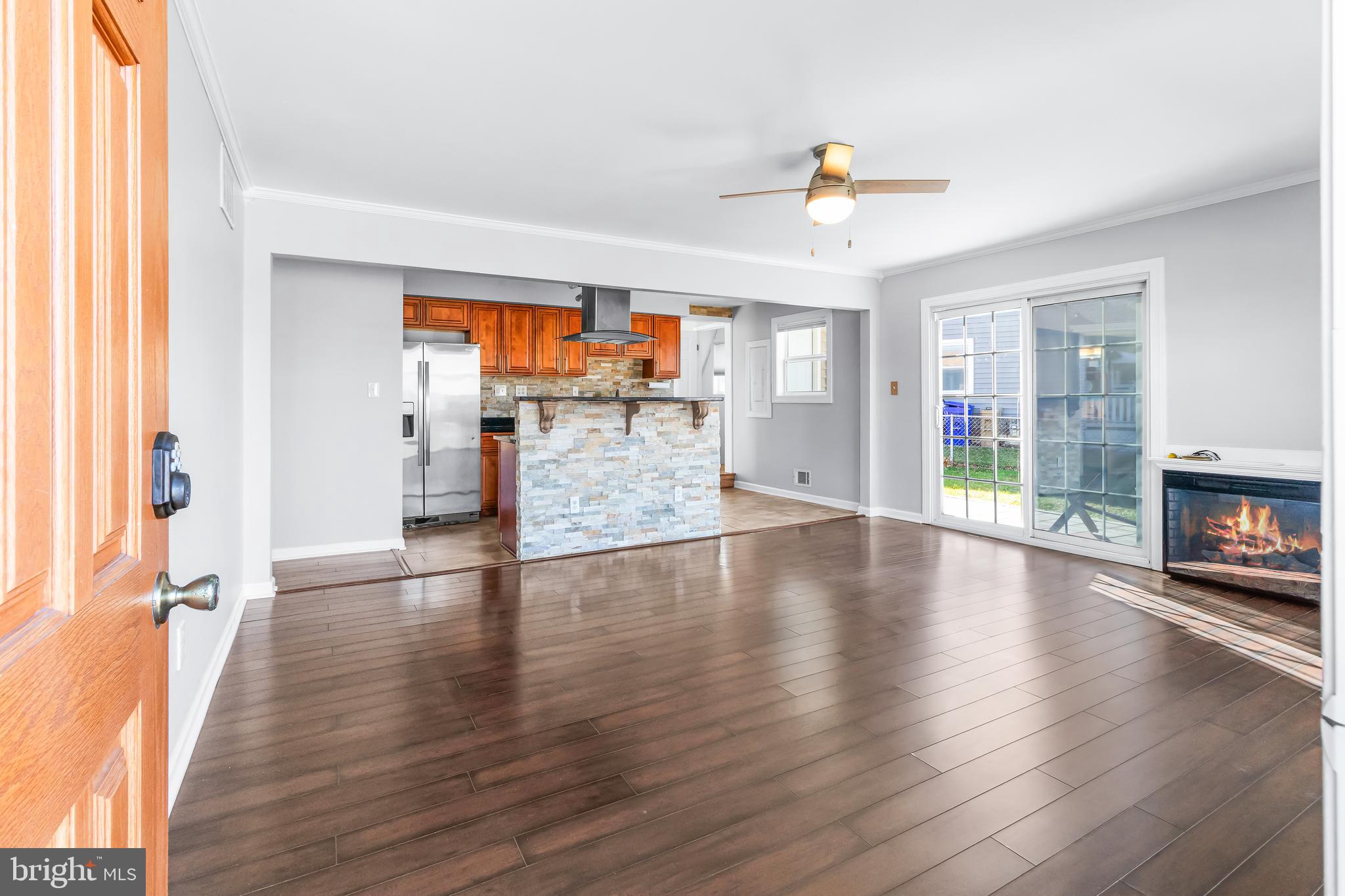 1000 8th Street Laurel, MD 20707 - Photo 6 of 45 an empty room with wooden floor fireplace and windows