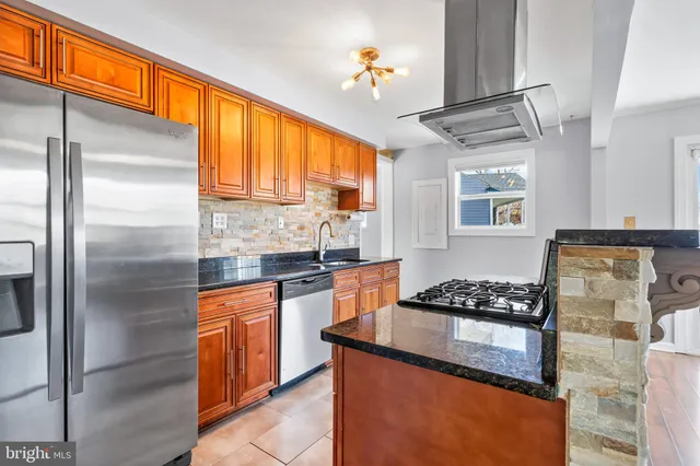 a kitchen with stainless steel appliances granite countertop a refrigerator a sink dishwasher a stove and white countertops with wooden floor