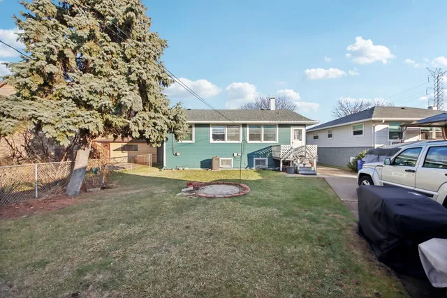 a view of a house with backyard and a tree