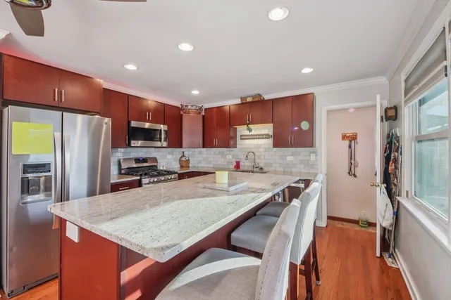 a kitchen with stainless steel appliances granite countertop a refrigerator a stove top oven a sink and dishwasher