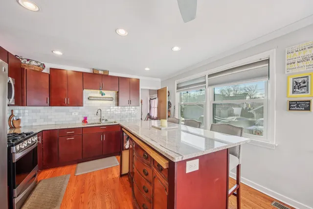 a kitchen with stainless steel appliances granite countertop a sink stove and refrigerator