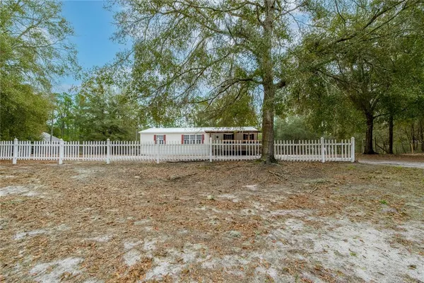 a view of a yard with wooden fence and trees