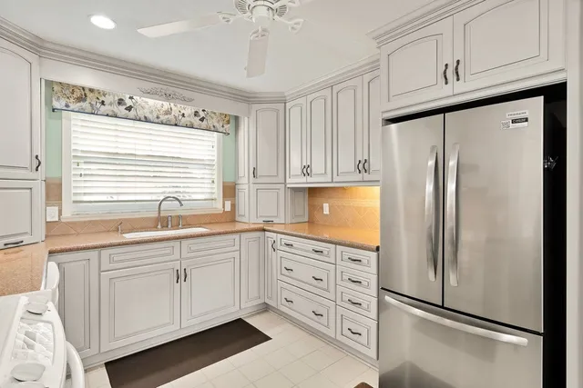 a kitchen with stainless steel appliances a refrigerator sink and cabinets