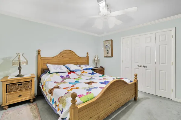 a bedroom with a bed and a ceiling fan