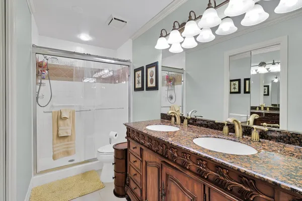 a bathroom with a granite countertop sink a large mirror and a shower