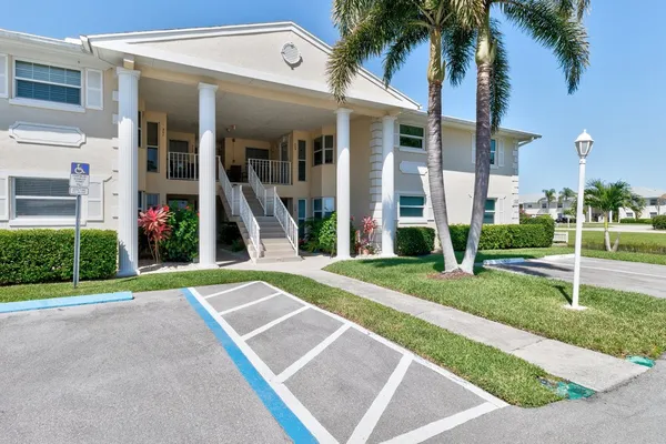 a view of a house with backyard and a tree
