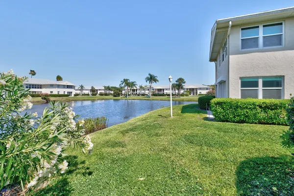 a view of a house with a yard and a fountain