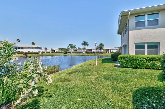 a view of a house with a yard and a fountain