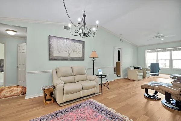 a living room with furniture chandelier and a table