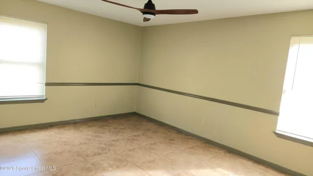 a view of a big room with wooden floor and windows