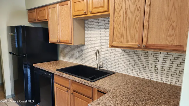 a view of kitchen with stainless steel appliances granite countertop a stove and a sink