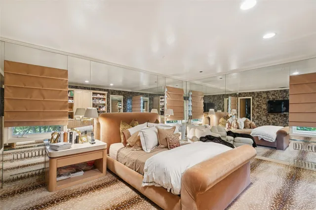 a spacious bedroom with a bed and wooden floor