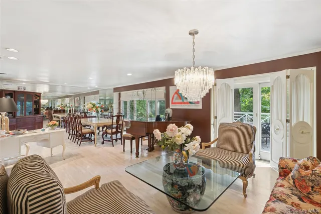 a living room with furniture chandelier and a large window