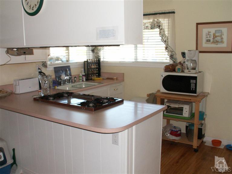 4512 Alpine Street Simi Valley, CA 93063 - Photo 8 of 11 a kitchen with a stove a microwave and a table