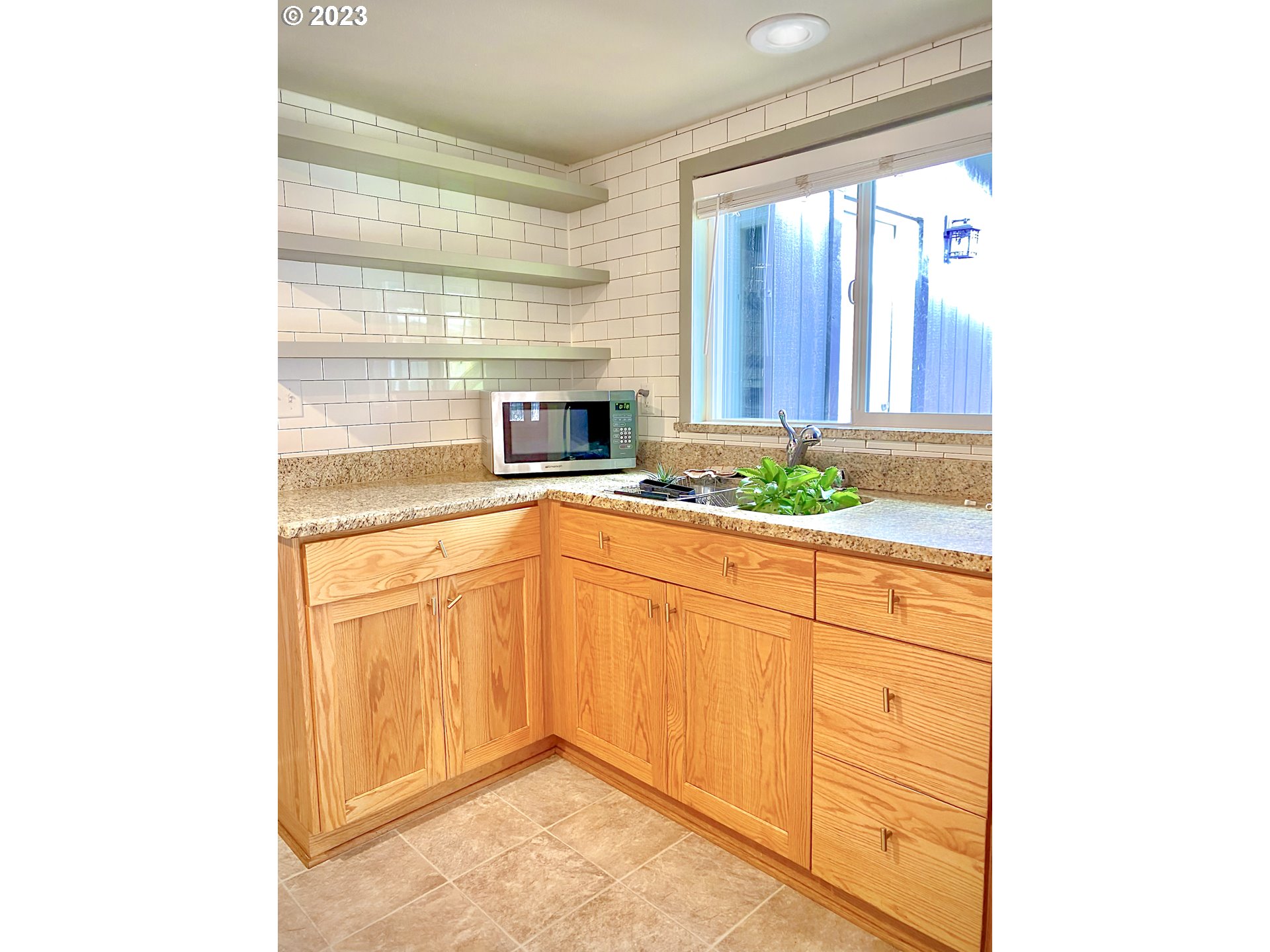 1344 S Street Springfield, OR 97477 - Photo 18 of 30 a kitchen with granite countertop white cabinets and white appliances