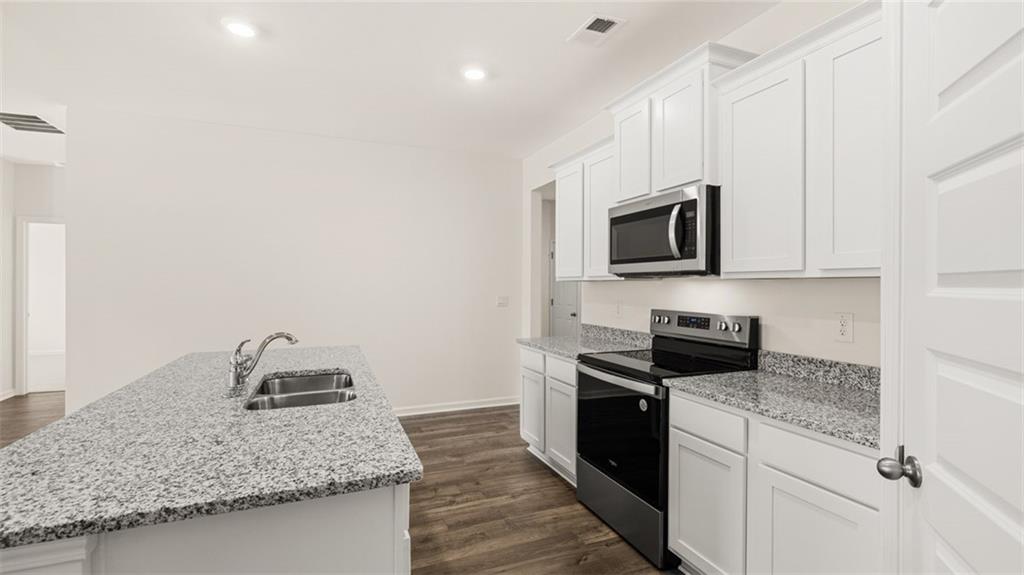 635 Whitman Lane Stockbridge, GA 30281 - Photo 13 of 42 a kitchen with granite countertop a sink and steel appliances
