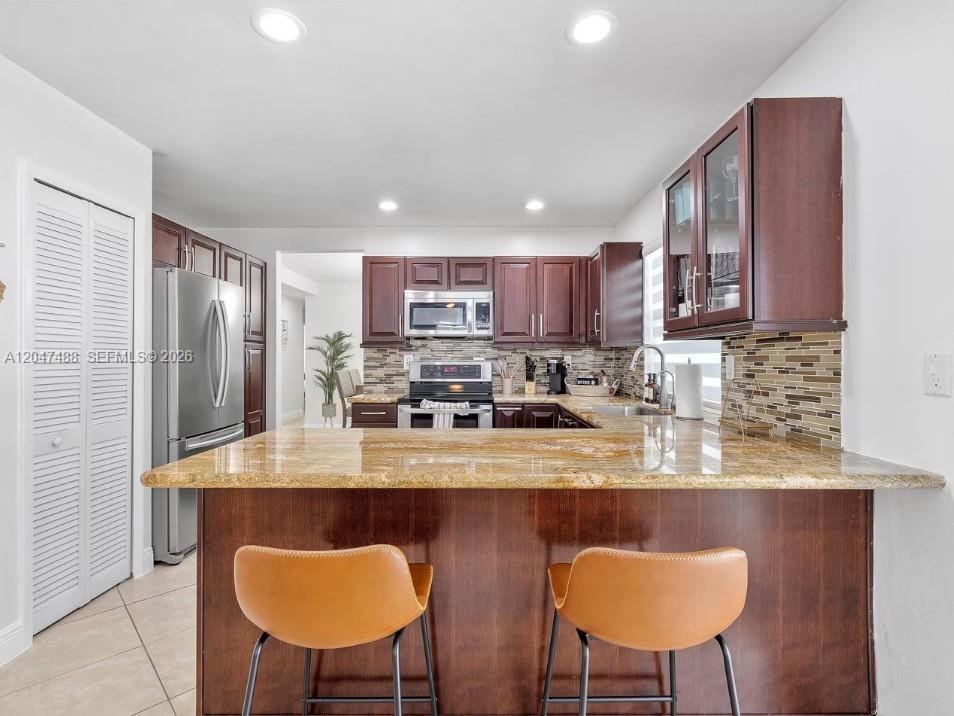 9840 Southwest 3rd Street Miami, FL 33174 - Photo 12 of 25 a kitchen with stainless steel appliances granite countertop a sink a stove a refrigerator cabinets and chairs