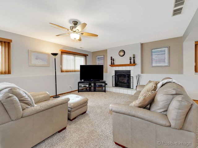705 Rockhurst Road Bolingbrook, IL 60440 - Photo 11 of 25 a living room with furniture a flat screen tv and a fireplace