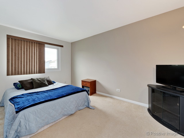 705 Rockhurst Road Bolingbrook, IL 60440 - Photo 18 of 25 a bedroom with a bed and a flat screen tv