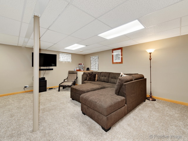 705 Rockhurst Road Bolingbrook, IL 60440 - Photo 19 of 25 a living room with furniture a flat screen tv and a refrigerator