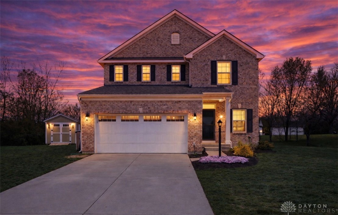 7900 Timberview Court Franklin, OH 45005 - Photo 1 of 60 An inviting facade with classic brickwork and a manicured lawn under a vivid sunset sky.