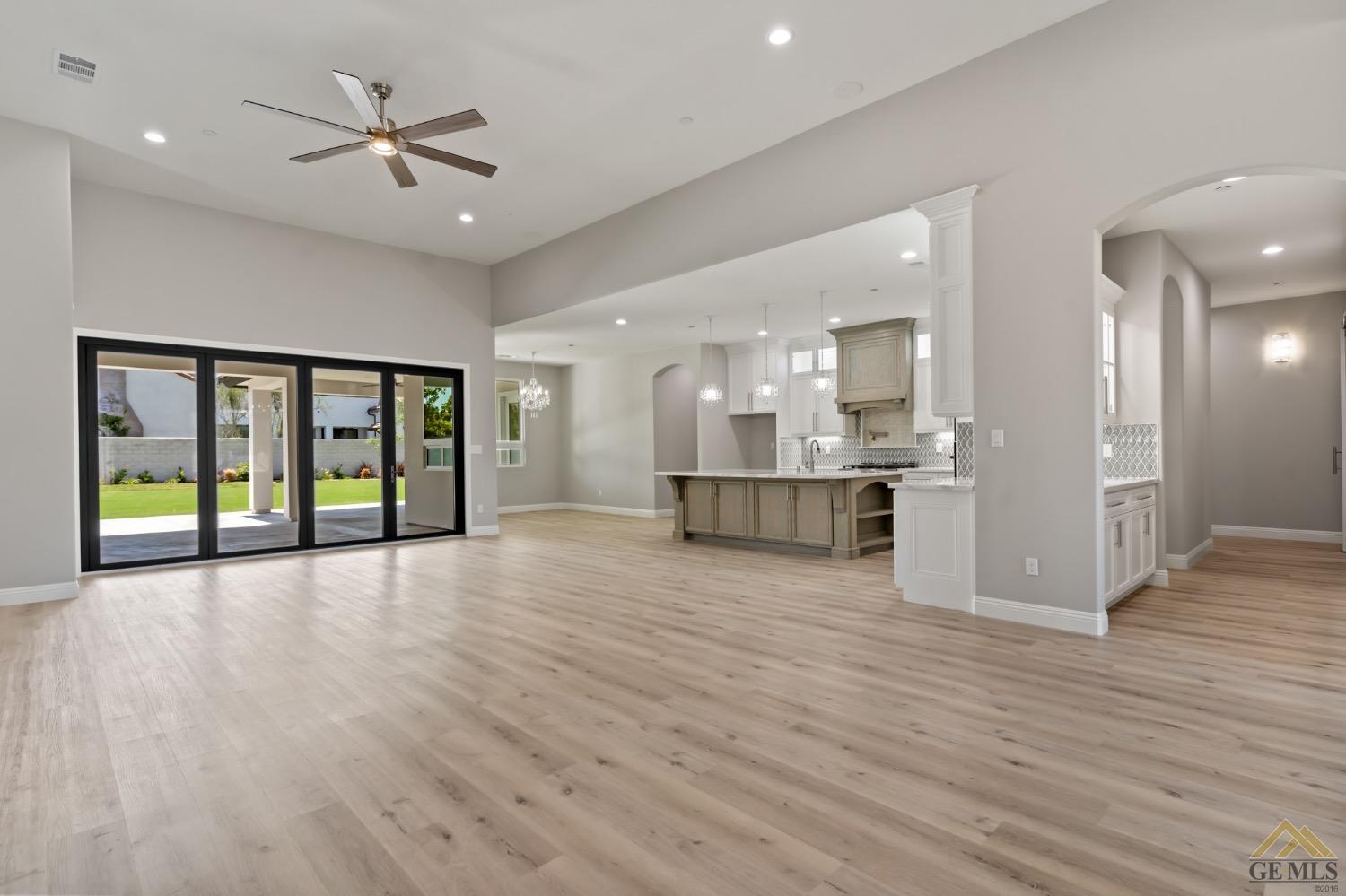 Undisclosed Address Bakersfield, CA 93311 - Photo 14 of 75 a view of an empty room with wooden floor and a kitchen