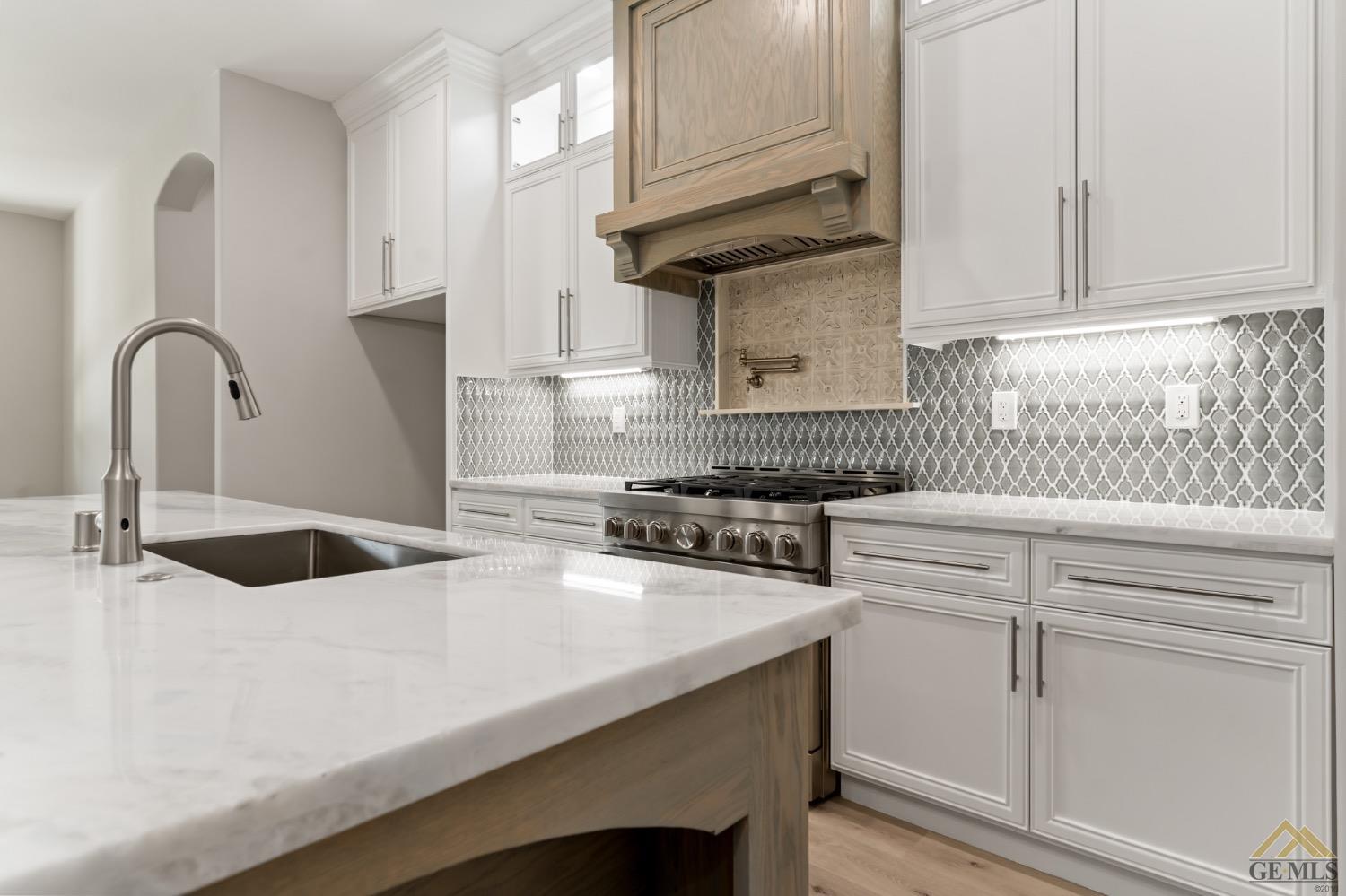 Undisclosed Address Bakersfield, CA 93311 - Photo 22 of 75 a kitchen with granite countertop a sink a stove and cabinets
