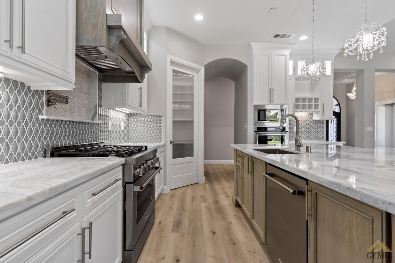 Undisclosed Address Bakersfield, CA 93311 - Photo 23 of 75 a kitchen with stainless steel appliances granite countertop a sink a stove and a wooden floors