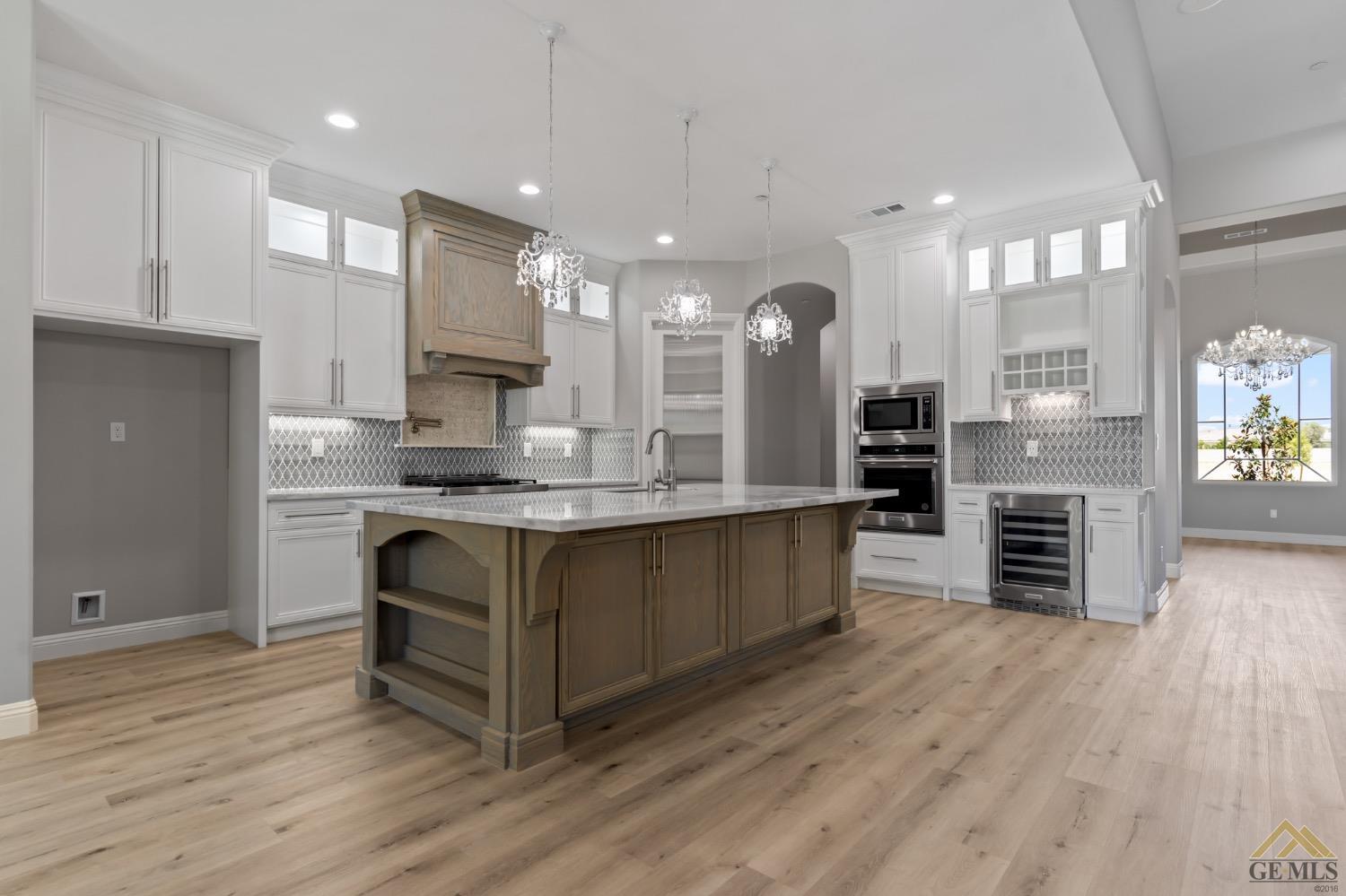 Undisclosed Address Bakersfield, CA 93311 - Photo 24 of 75 a large kitchen with stainless steel appliances kitchen island granite countertop a large counter top and stove