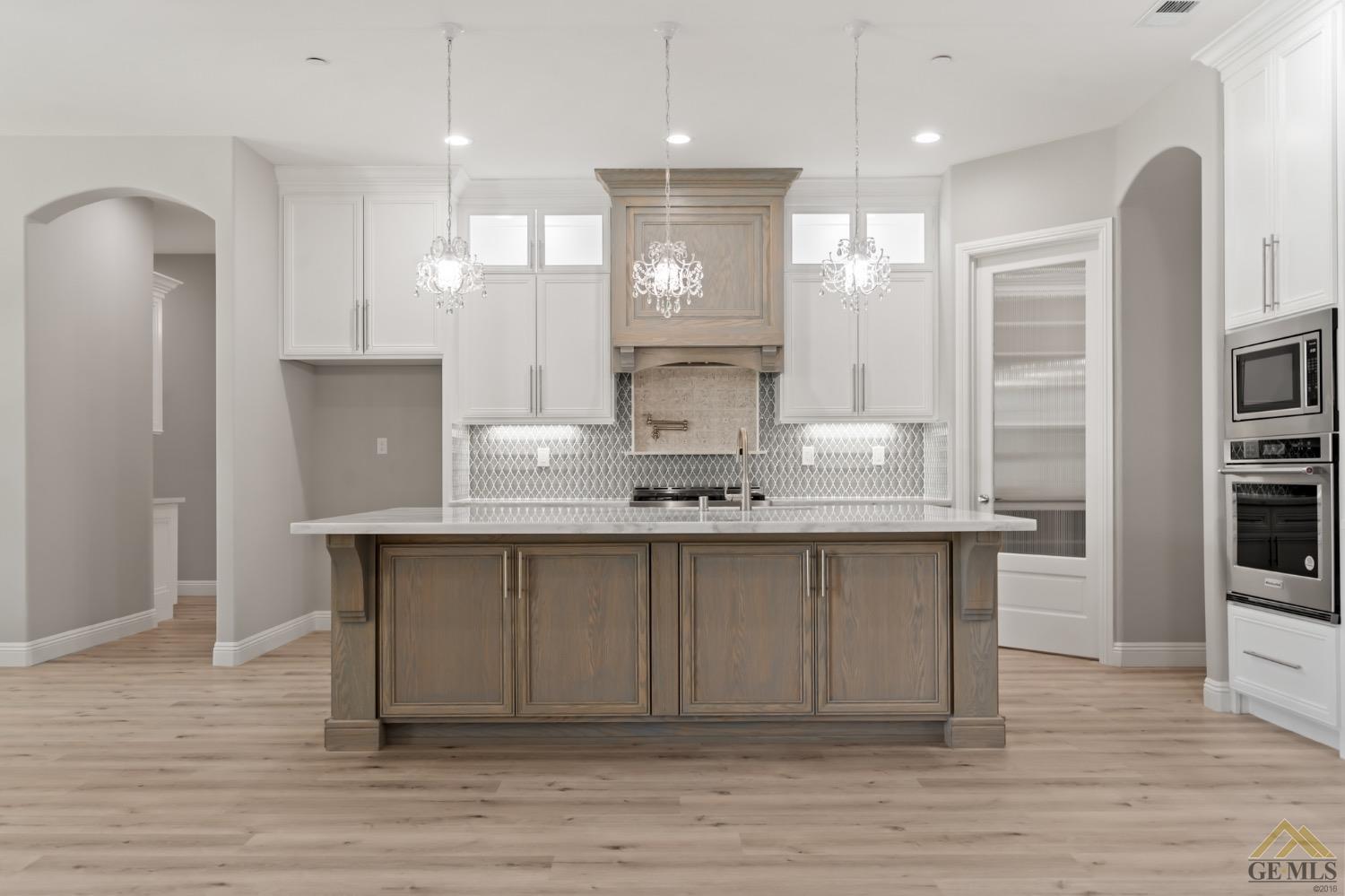 Undisclosed Address Bakersfield, CA 93311 - Photo 25 of 75 a large kitchen with granite countertop a large counter top space sink and stainless steel appliances