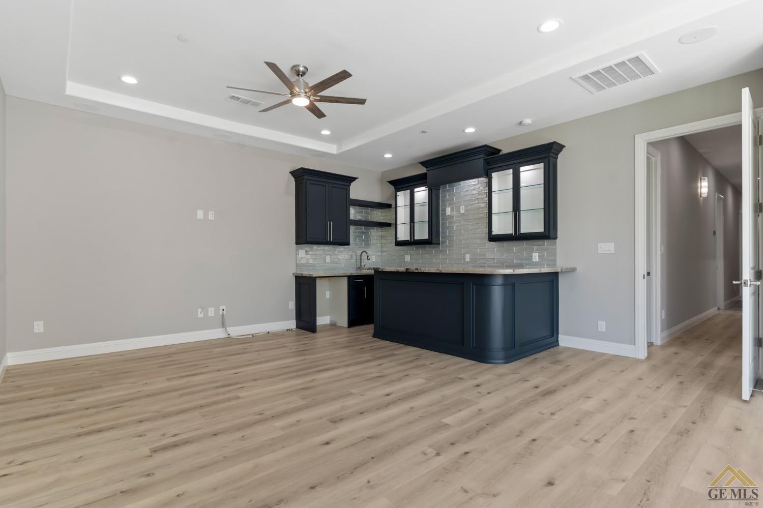 Undisclosed Address Bakersfield, CA 93311 - Photo 74 of 75 a large kitchen with stainless steel appliances granite countertop a sink dishwasher and a fireplace with wooden floor
