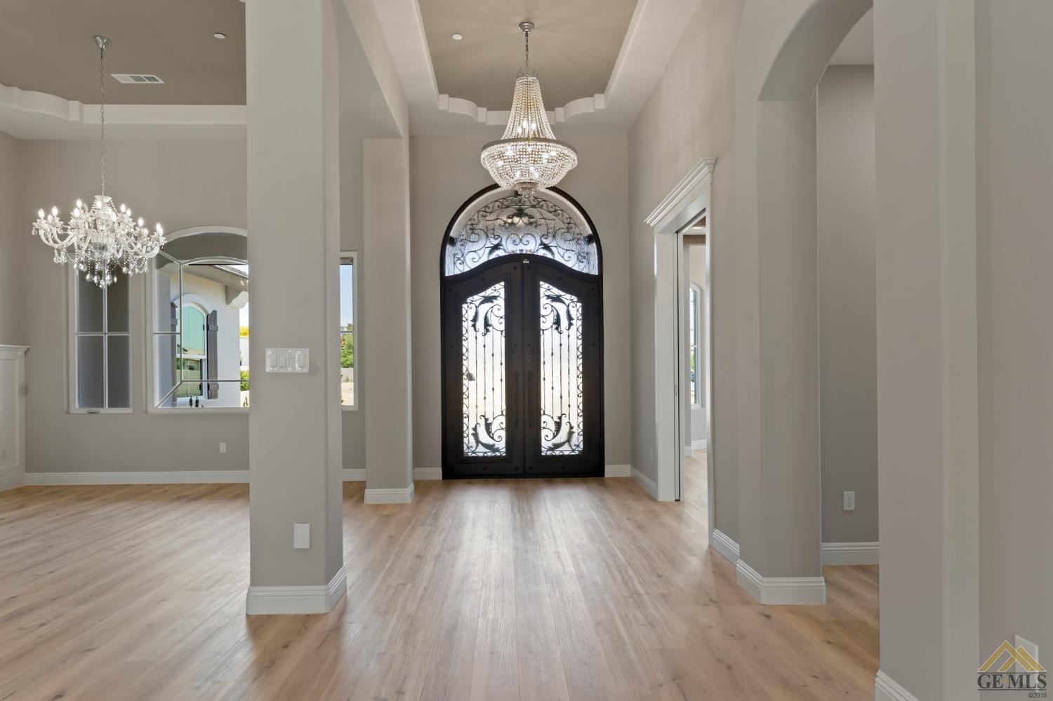 Undisclosed Address Bakersfield, CA 93311 - Photo 9 of 75 a view of a hallway with wooden floor and a chandelier