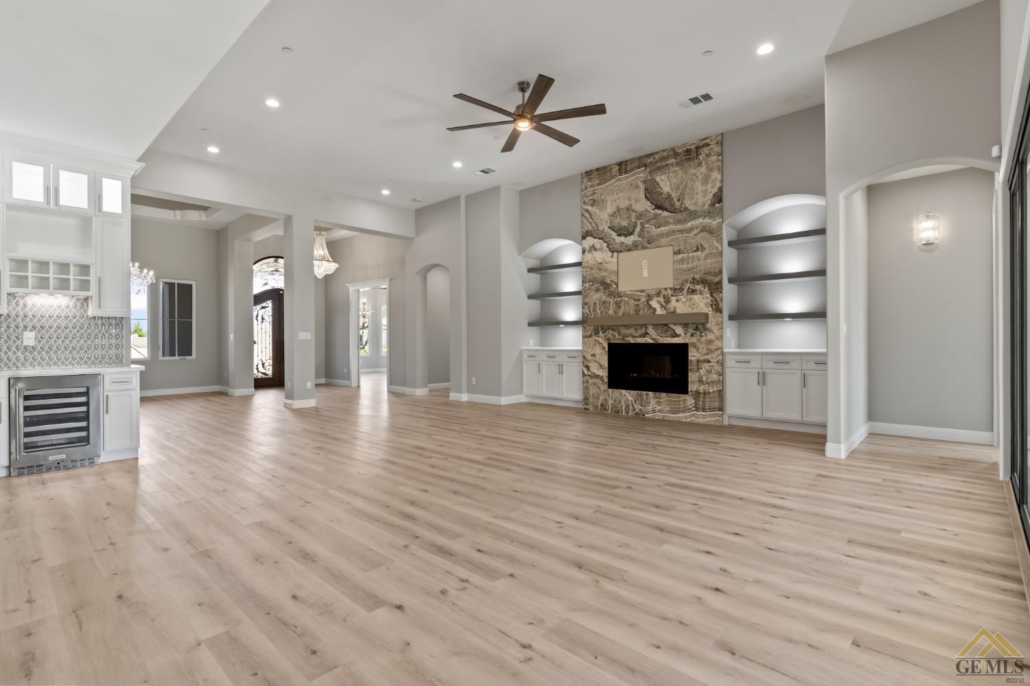 Undisclosed Address Bakersfield, CA 93311 - Photo 10 of 75 an empty room with wooden floor a ceiling fan and windows