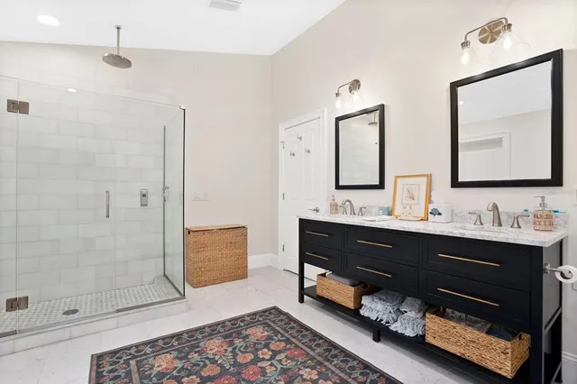 a bathroom with a double vanity sink mirror and shower