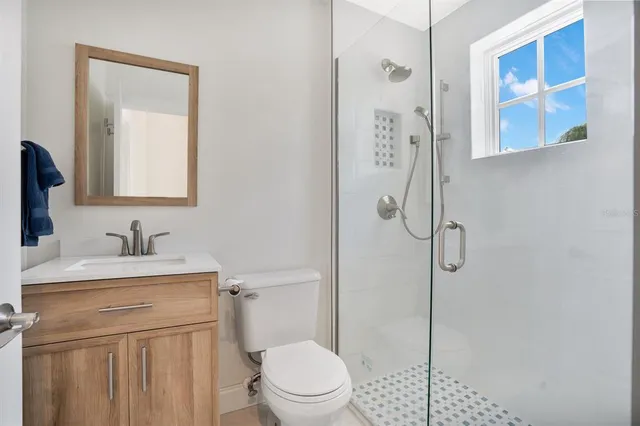 a bathroom with a granite countertop sink toilet and shower