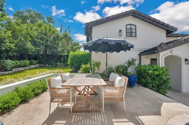 a patio with a table and chairs under an umbrella