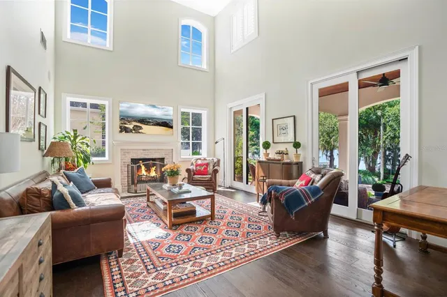 a living room with fireplace furniture and floor to ceiling windows