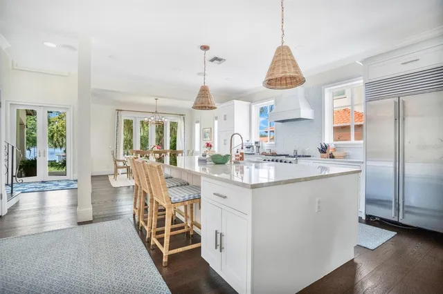 a kitchen with stainless steel appliances granite countertop a kitchen island hardwood floor and a sink