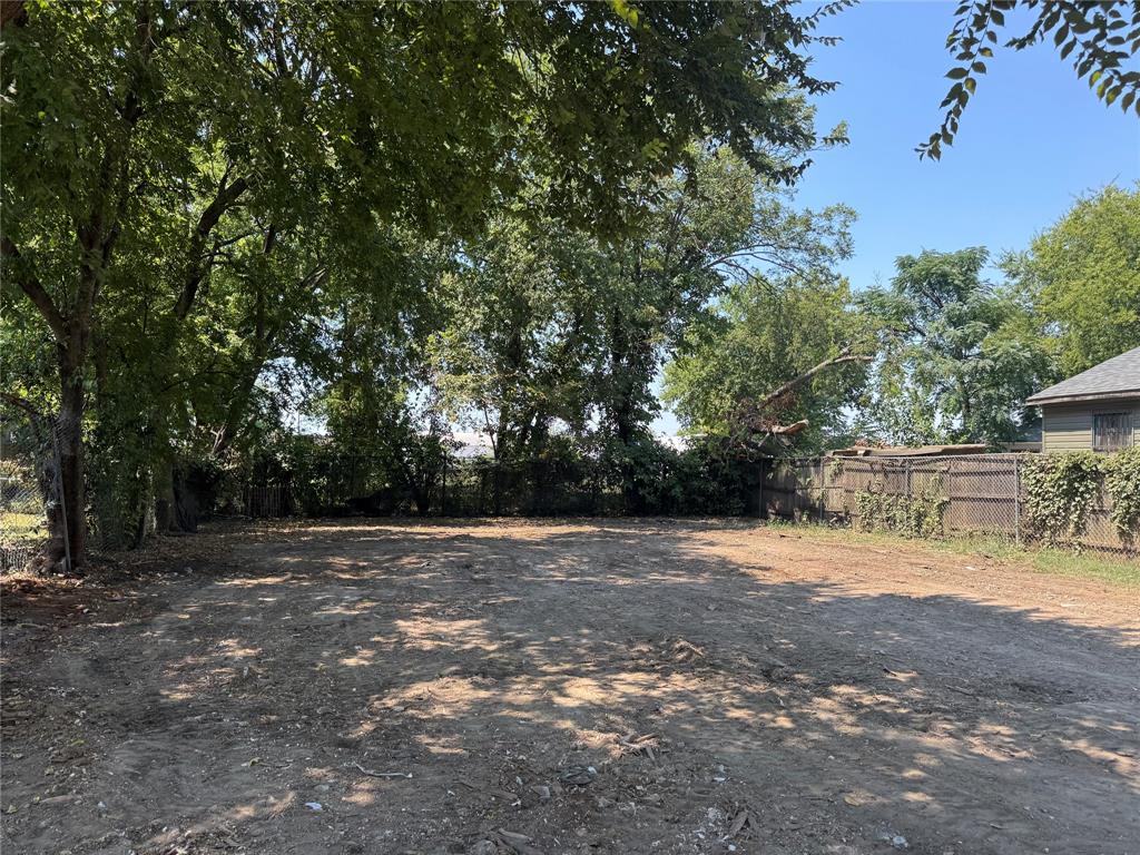 a view of backyard with tree and wooden fence