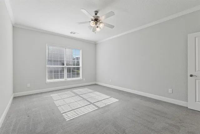 an empty room with windows and ceiling fan