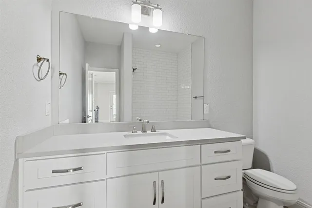 a bathroom with a sink a toilet and mirror