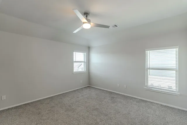 a view of an empty room with a chandelier fan